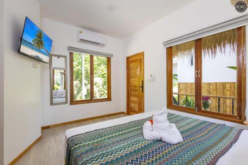 a bedroom with a bed with white shoes on it at BOHO Boutique Bungalows in Baan Tai