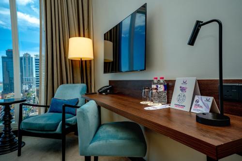 a hotel room with a desk and two chairs at Sofia Colombo City Hotel in Colombo