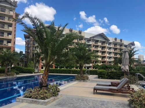 a resort with a palm tree and a swimming pool at Two Bedroom with Balcony 70sqm -Pasig in Manila
