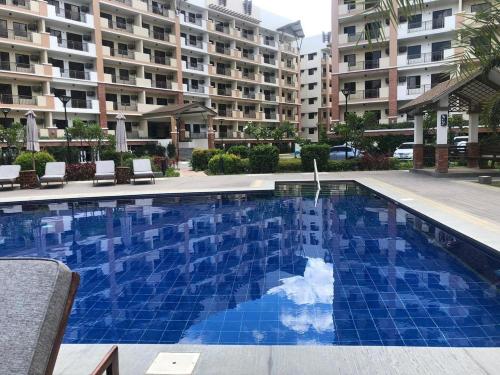 a swimming pool in front of a large apartment building at Two Bedroom with Balcony 70sqm -Pasig in Manila
