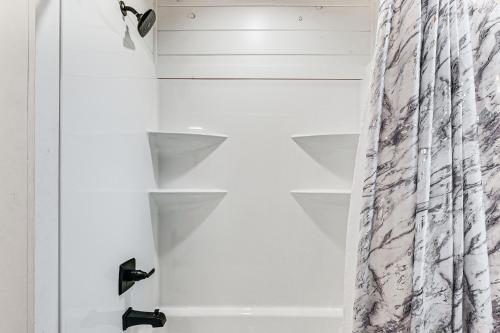 a closet with white shelves and a curtain at 6 Mi to Broken Bow Lake Home with Game Room! in Stephens Gap