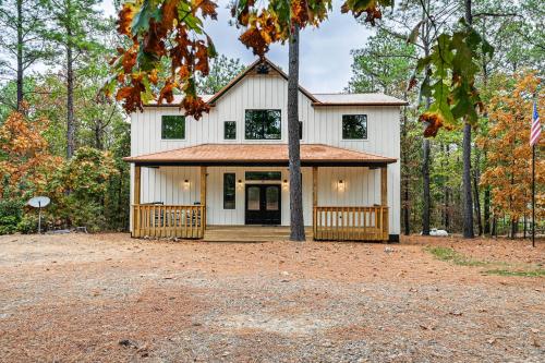 a white house with a tree in front of it at 6 Mi to Broken Bow Lake Home with Game Room! in Stephens Gap