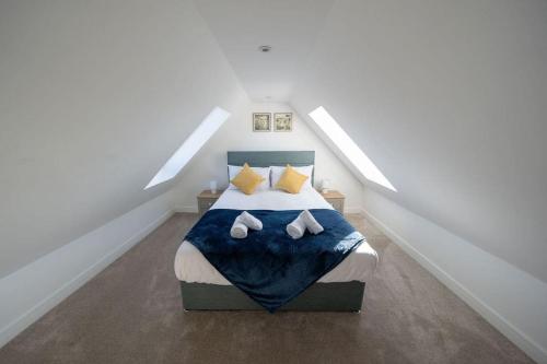 a bedroom with a bed with a blue blanket and yellow pillows at Easter Cottage -4 Bed Converted Barn Cottage in Turriff