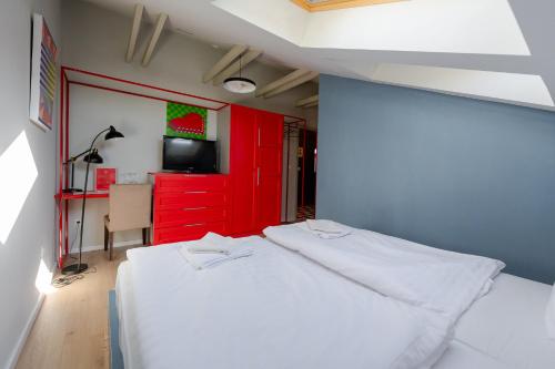 a bedroom with a white bed and a red cabinet at Bohém Borklub in Tállya