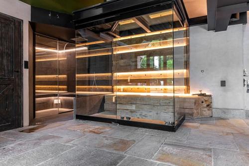 - un hall avec un banc en bois et un mur en verre dans l'établissement Demeure A Fleur de Rance -5 étoiles- Saint-Malo, à Saint-Malo