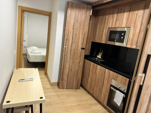 Kleines Zimmer mit einem Tisch und einer Mikrowelle. in der Unterkunft Apartamentos Turísticos SANTA APOLONIA 62 in Avilés