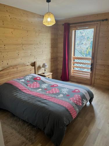 Ce lit se trouve dans une chambre en bois dotée d'une fenêtre. dans l'établissement Appartement 6 personnes au cœur de Valmeinier - Céleste 102, à Valmeinier