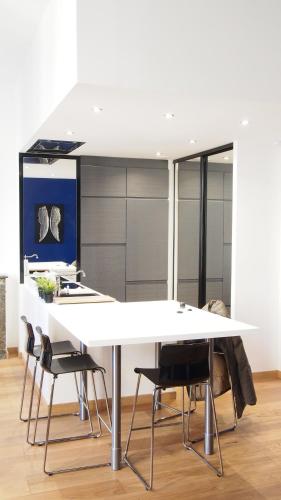 une cuisine avec une grande table blanche et des chaises dans l'établissement ATYPIQUE Grand théâtre, à Bordeaux