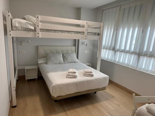 1 Schlafzimmer mit 2 Etagenbetten und Handtüchern auf dem Bett in der Unterkunft Apartamentos Turísticos SANTA APOLONIA 62 in Avilés