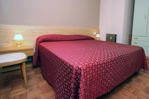 a bedroom with a bed with a red comforter at Champoluc Apartment in Champoluc