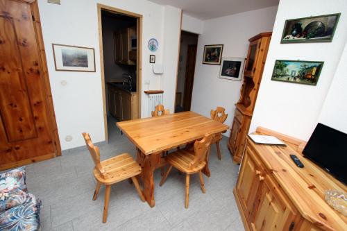 a dining room with a wooden table and chairs at Champoluc Apartment in Champoluc
