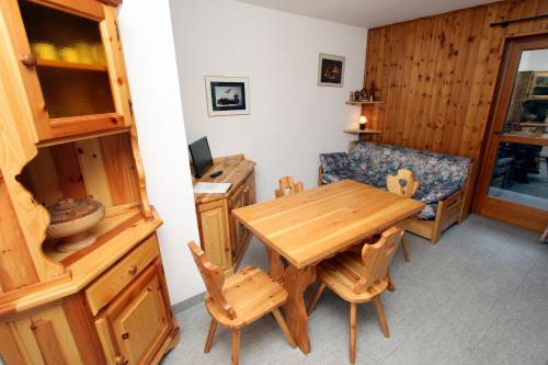 a dining room with a wooden table and chairs at Champoluc Apartment in Champoluc