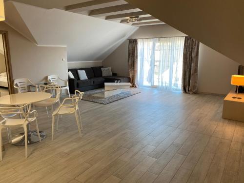 a living room with a couch and a table and chairs at SleepWell Apartments Czarna Góra in Sienna