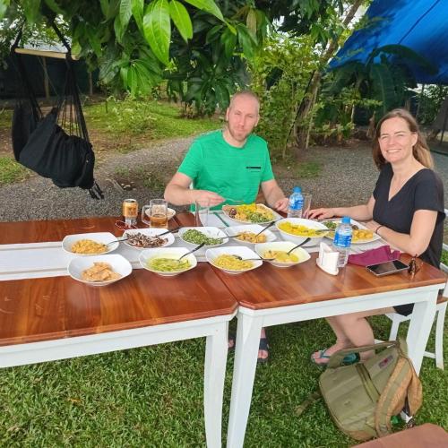 a man and a woman sitting at a table with food at Harmony Haven, Udawalawe, Sri Lanka in Udawalawe