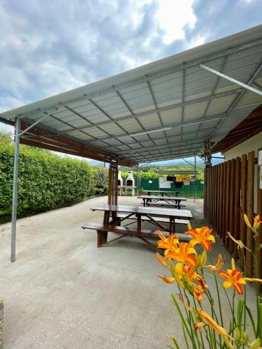 a group of picnic tables under a canopy at Agricampeggio Paolino in Pietramurata
