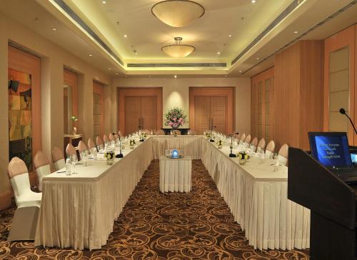 a conference room with a long table with white tables and chairs at Park Plaza Faridabad in Faridabad