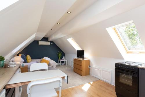 a kitchen and living room in an attic at Stunning studio flat with dedicated private garden in Shrewsbury