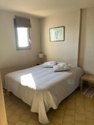 une chambre avec un grand lit avec deux oreillers dans l'établissement Le Bleu Mer, aux Issambres