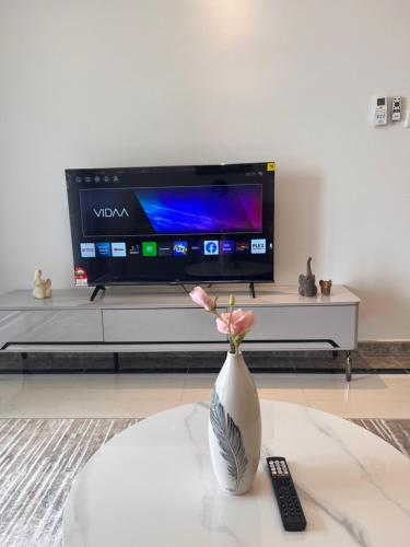 a vase with flowers in front of a tv at R&F Princess Cove View Residences by WSD in Johor Bahru