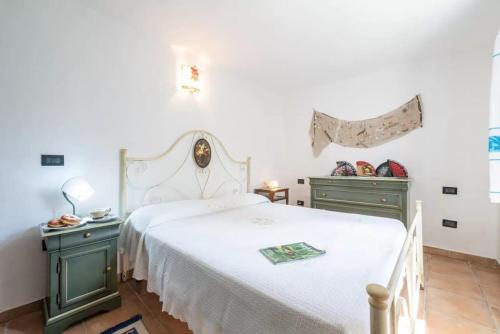 a bedroom with a white bed and green cabinets at Al mare a Capo Comino in Capo Comino