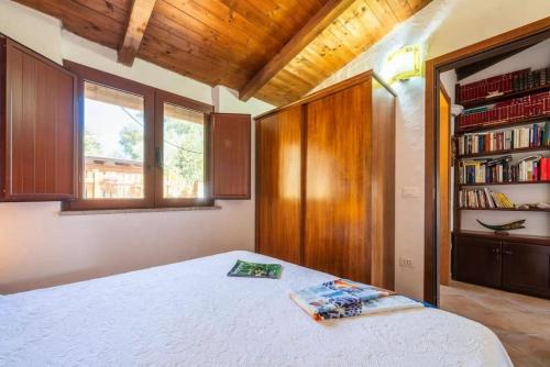 a bedroom with a bed and a book shelf at Al mare a Capo Comino in Capo Comino