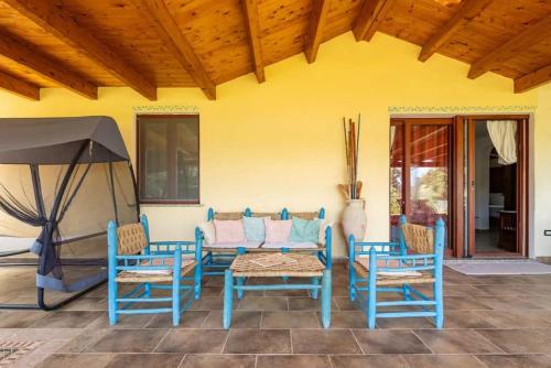 a patio with a table and chairs and an umbrella at Al mare a Capo Comino in Capo Comino