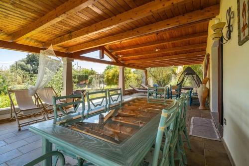a patio with a green table and chairs at Al mare a Capo Comino in Capo Comino