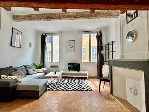 un salon avec un canapé et une cheminée dans l'établissement Charmant T1 mezzanine provençal, à Aix-en-Provence