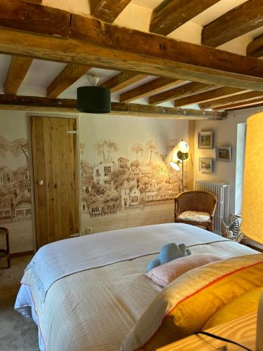 a bedroom with a large bed with a mural on the wall at Gîtes et Spa en Normandie in Sainte-Marguerite-de-Viette