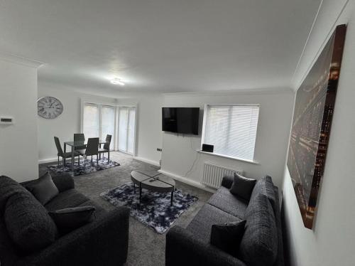 a living room with a couch and a table at The Modern Balcony Apartment - 2 Bed 1 Bath Private Parking in Milton Keynes