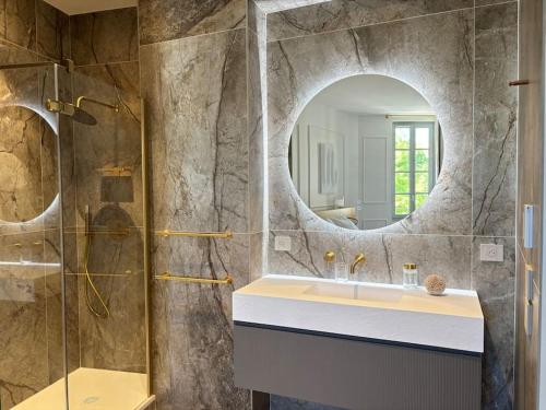 une salle de bain avec un lavabo et un miroir dans l'établissement Le Pénélope, à Aix-en-Provence