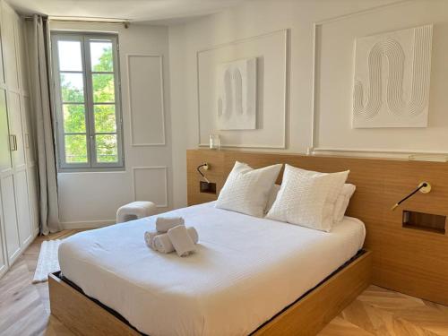 - un ours en peluche assis sur un lit dans une chambre dans l'établissement Le Pénélope, à Aix-en-Provence