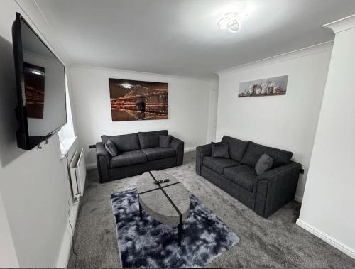 a living room with two couches and a tv at The Modern Balcony Apartment - 2 Bed 1 Bath Private Parking in Milton Keynes