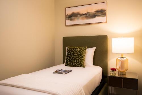 a small bedroom with a bed with a lamp on it at The Pathmaker Hotel in Bar Harbor