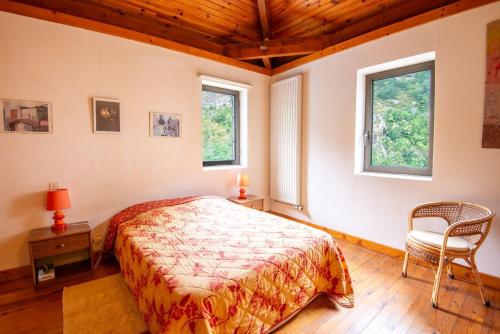- une chambre avec un lit, une chaise et deux fenêtres dans l'établissement Gîte Appartement 