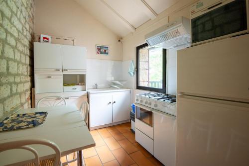 une petite cuisine avec des appareils électroménagers blancs et une table dans l'établissement Gîte Appartement 