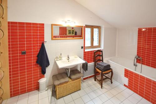 a bathroom with red tiles and a sink and a tub at Wooden house in Vysočina in Jihlava
