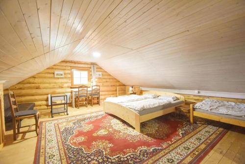 a bedroom with two beds and a rug in a attic at Wooden house in Vysočina in Jihlava
