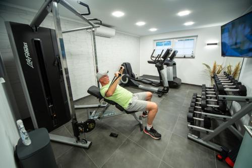 a man is sitting in a gym on a machine at Winkelschiffchen III mit Sauna in Juist