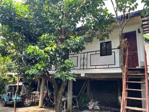 a house with a balcony and a tree at D's Haven Café in La Carlota