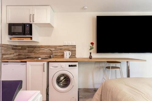 une cuisine avec un lave-linge et un comptoir avec un évier dans l'établissement Love Room avec Jacuzzi, Le Saccard, à Villeneuve-le-Roi