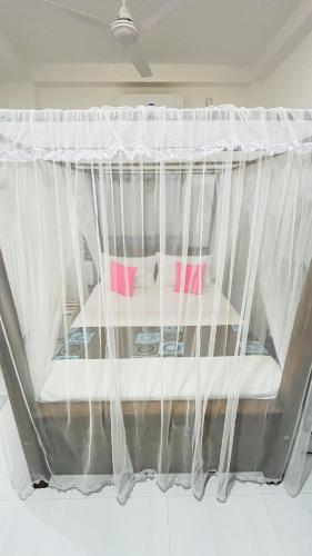 a bed with mosquito netting in a room at Jilan Homestay in Bentota