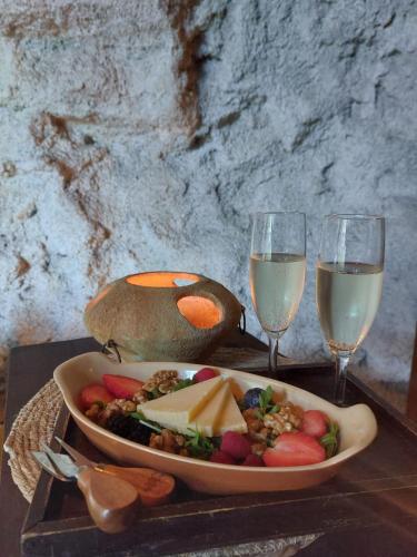a table with a plate of food and two glasses of wine at La Baita Suite in Sicignano degli Alburni