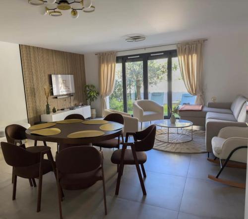 un salon avec une table, des chaises et un canapé dans l'établissement Havre de Paix avec jardin - Cote Azur Ste Maxime, à Sainte-Maxime