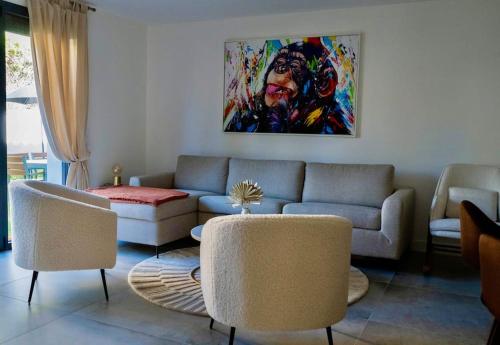 - un salon avec un canapé, des chaises et un tableau dans l'établissement Havre de Paix avec jardin - Cote Azur Ste Maxime, à Sainte-Maxime