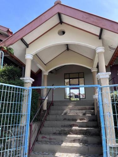 an entrance to a house with a blue fence at Belgareti Modern Ethnic House Cipanas Puncak in Cibadak