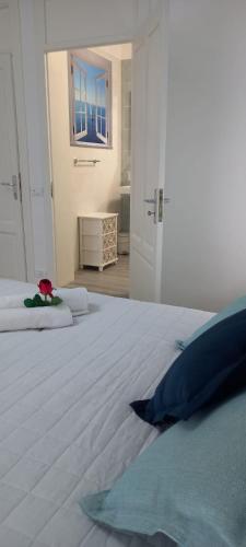 a bedroom with a large white bed with blue pillows at Regina Stella in Lascari