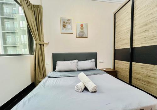 a bedroom with a bed with two towels on it at R&F Princess Cove View Residences by WSD in Johor Bahru
