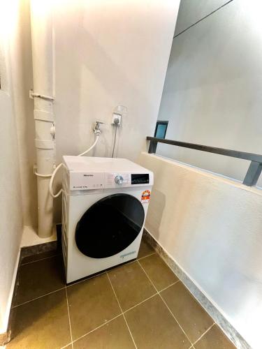 a microwave sitting in the corner of a bathroom at R&F Princess Cove View Residences by WSD in Johor Bahru