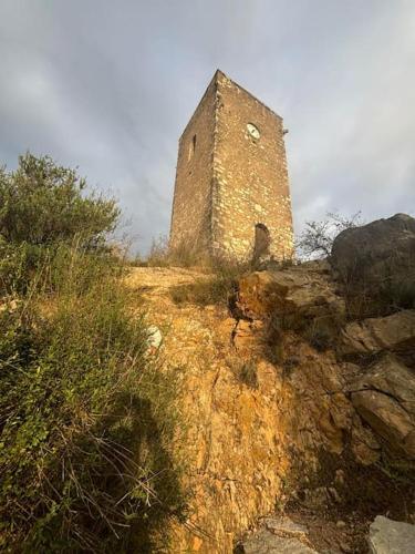 un vieux bâtiment au sommet d'une colline dans l'établissement Maison Charme et Modernité, à Cessenon